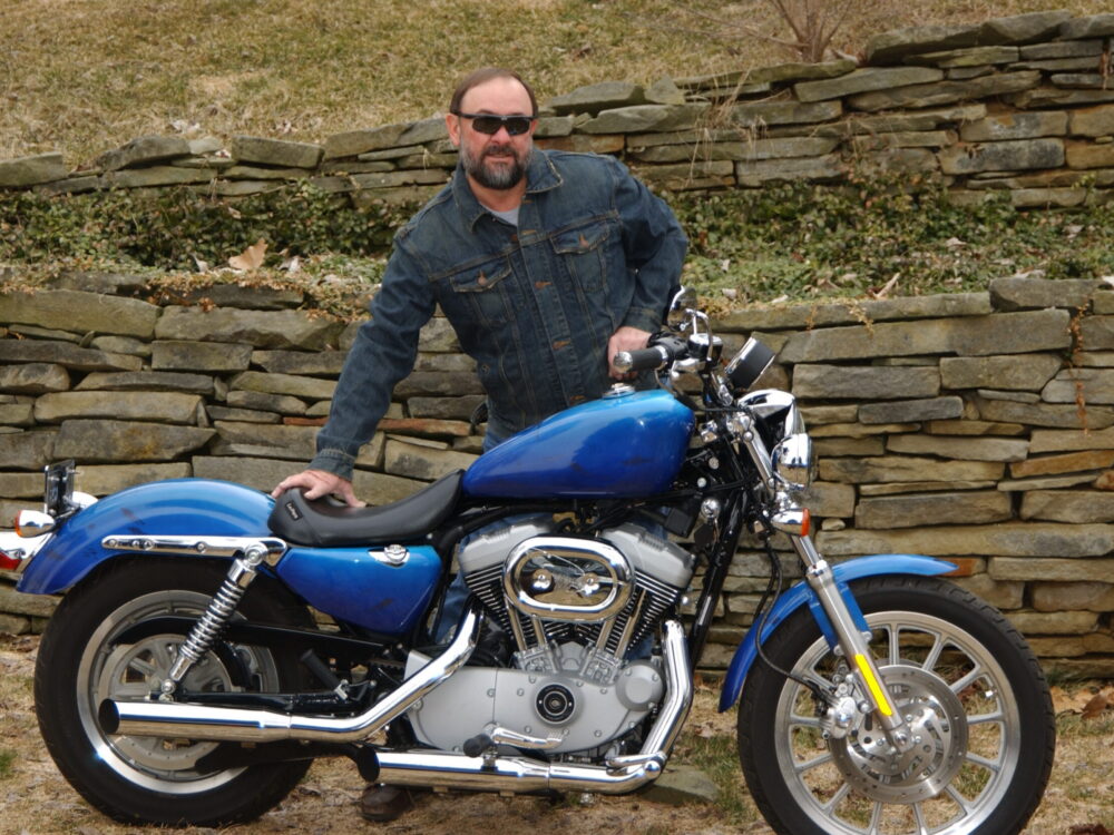 Jeff standing with his Harley